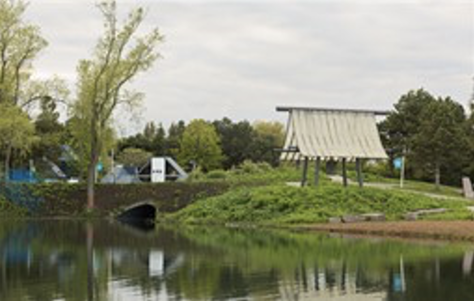 A picture of the Japense Temple Bell art piece reflecting on the water in the adjacent cove. 