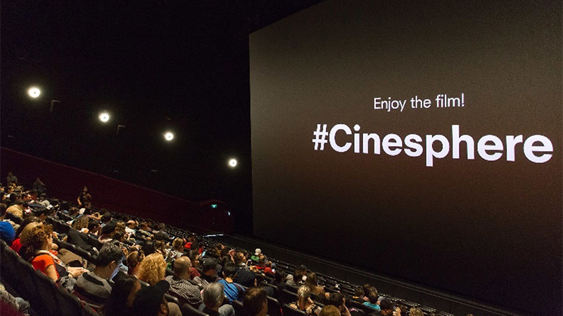 Photo de gens en train de regarder un film à la cinésphère. Légende « Enjoy the film! #Cinesphere » (« Appréciez le film! À la #Cinésphère »)