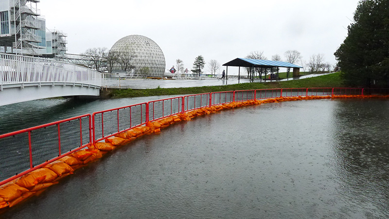 A gated off flooded area, adjacent to the cinesphere and a bridge. 