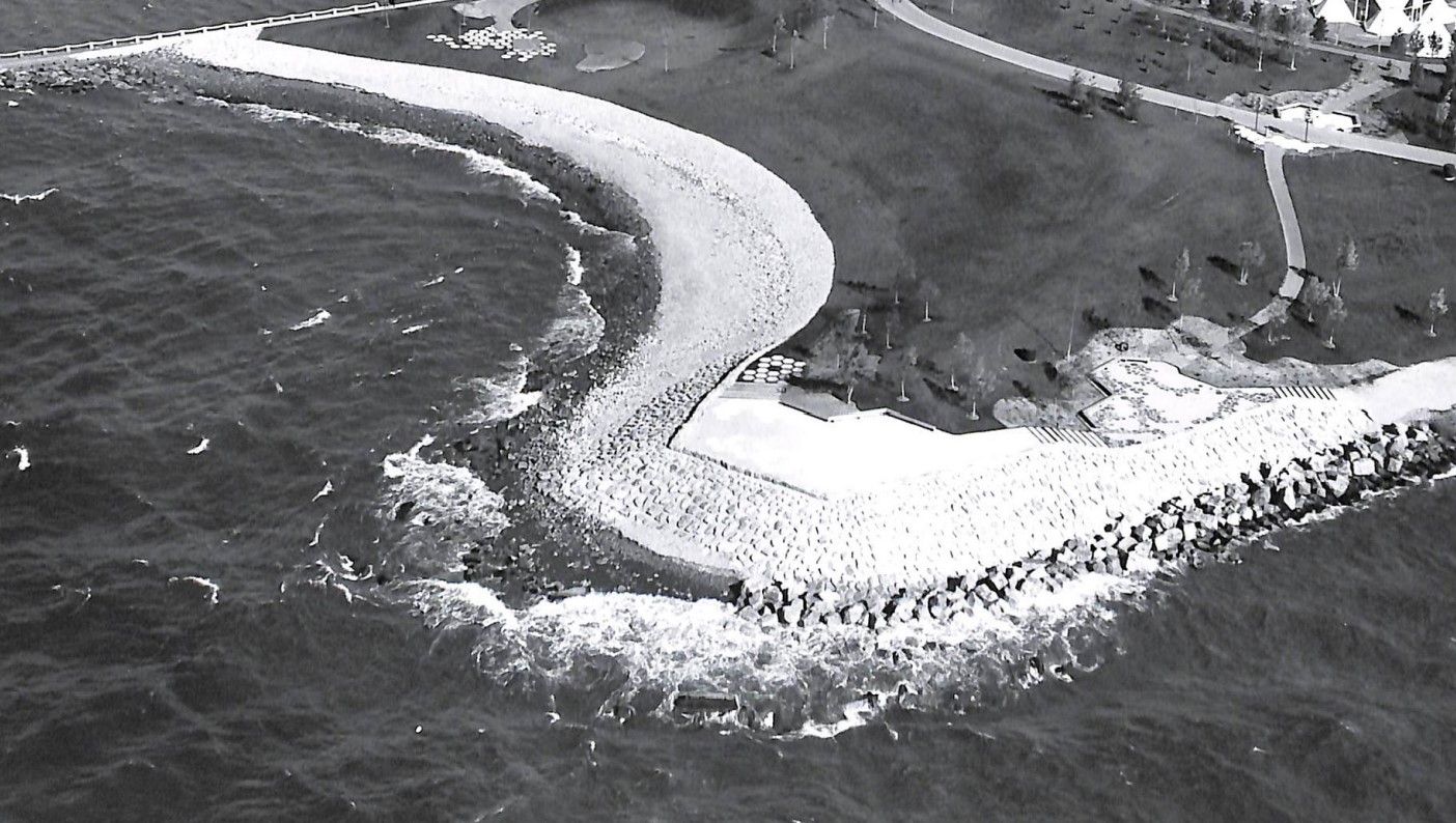 Black and white aerial photo of an armoured shoreline with a lookout point