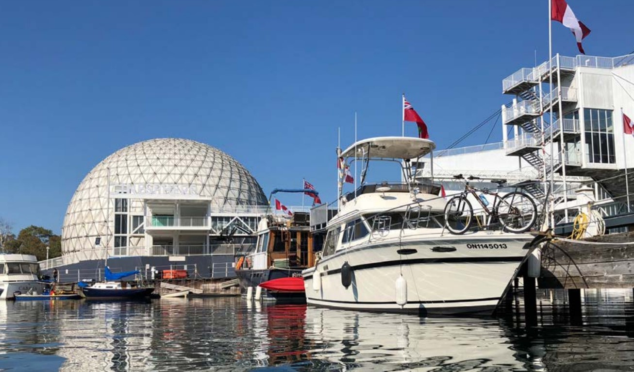 Two boats docked with the Cinesphere in the background.